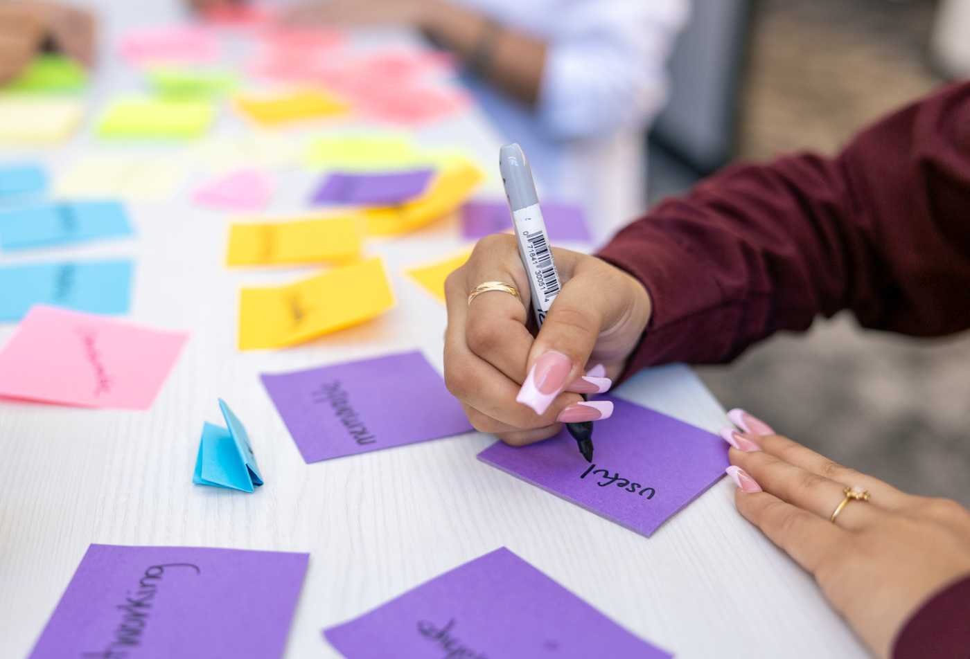 A team brainstorms with colorful notes, exploring organizations and collaboration in ASU's Interdisciplinary Organizational Studies minor.