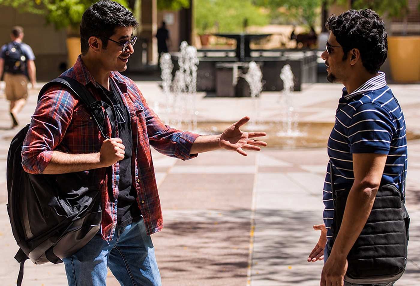 Students engage in discussion in front of a campus fountain, examining behavior and cognition in ASU's Psychology, BS program.