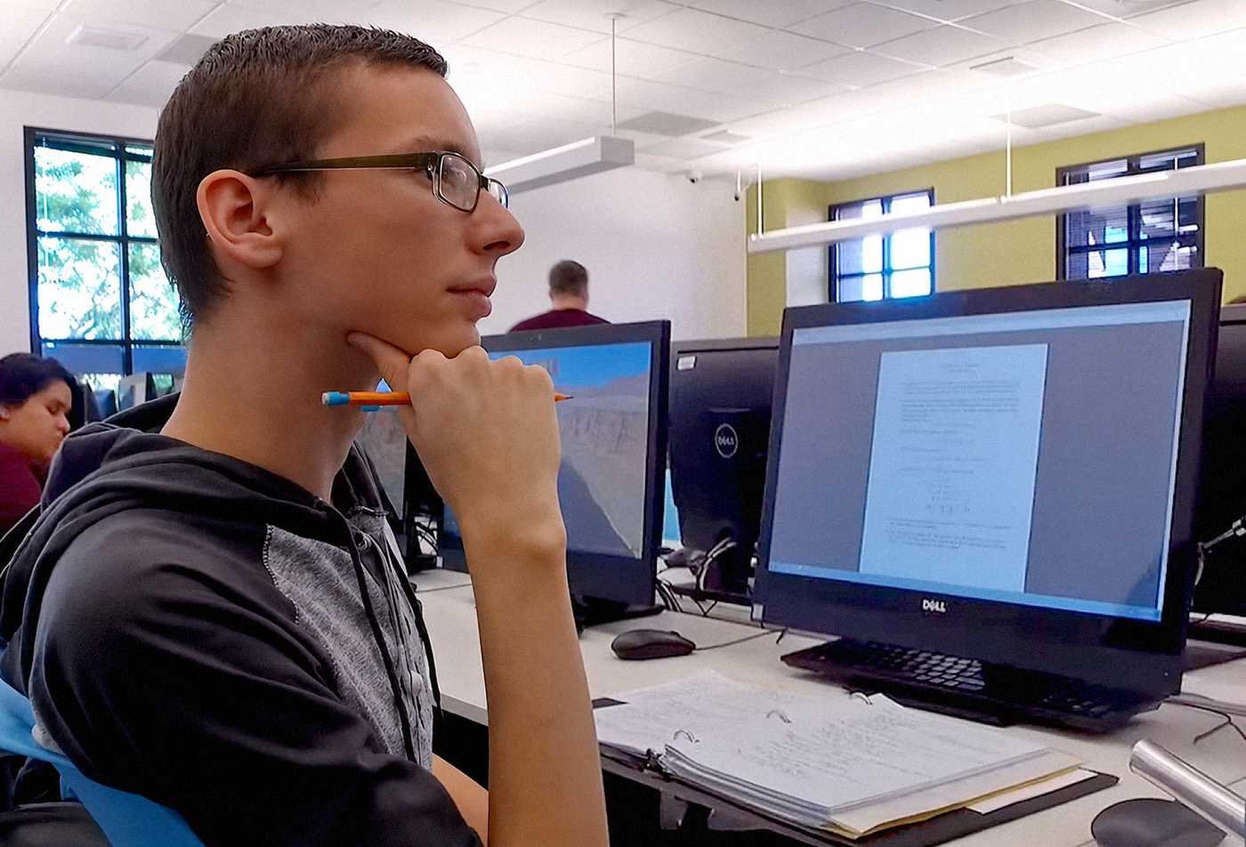 A student studies at a computer workstation, exploring evidence and behavior in ASU's Psychology (Forensic Psychology), BA program.
