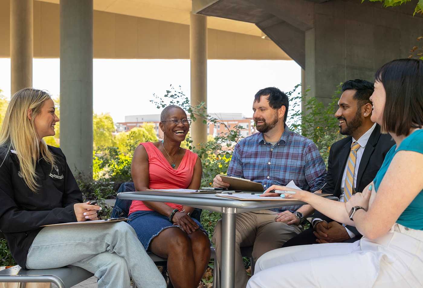 Professionals collaborate outdoors, exploring workplace dynamics in ASU's Psychology (Industrial and Organizational Psychology), BS program.
