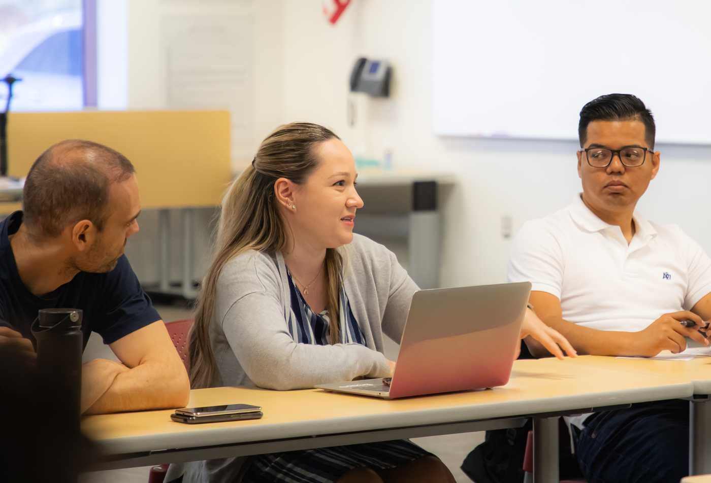 Adults engage in classroom discussion, reflecting critical inquiry and reasoning in ASU's Philosophy minor.