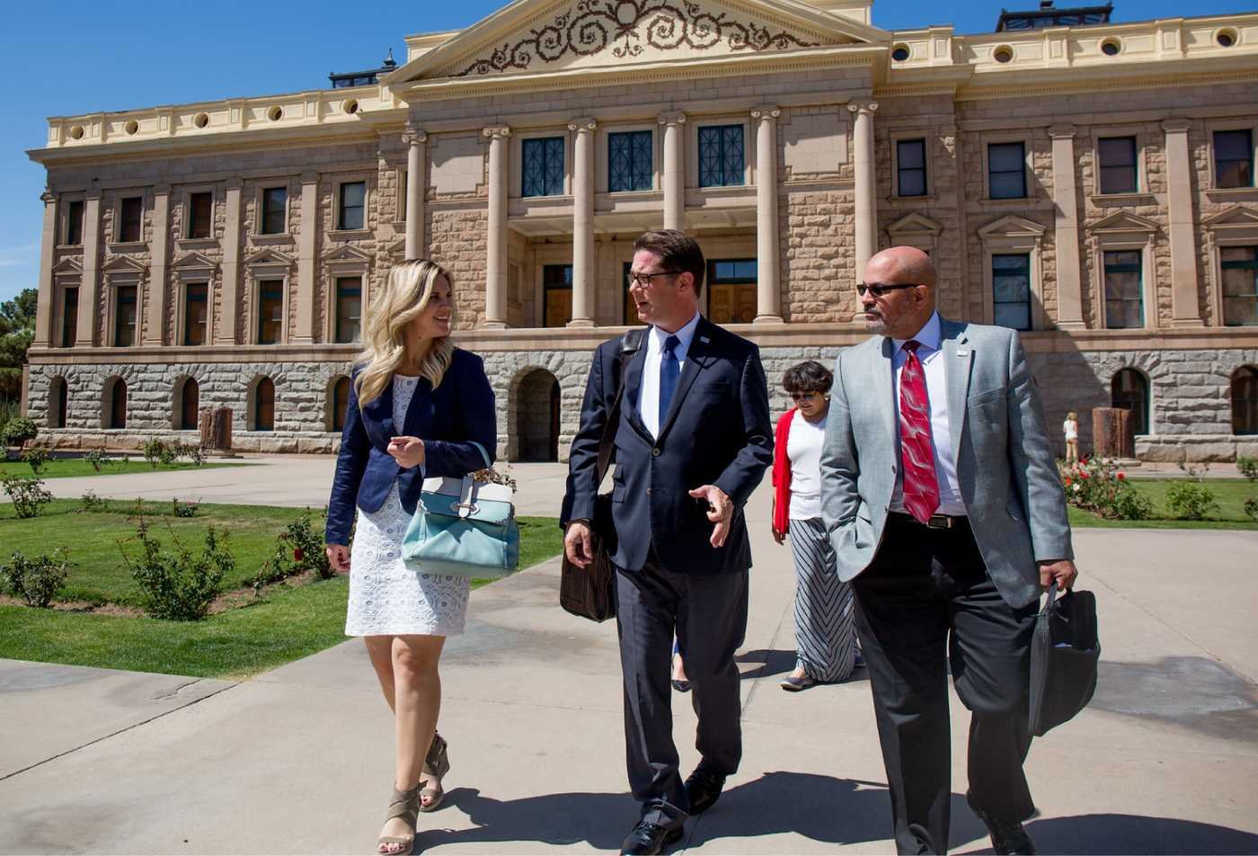 Professionals walk outside a government building, highlighting civic engagement in ASU's Political Science, BS program.