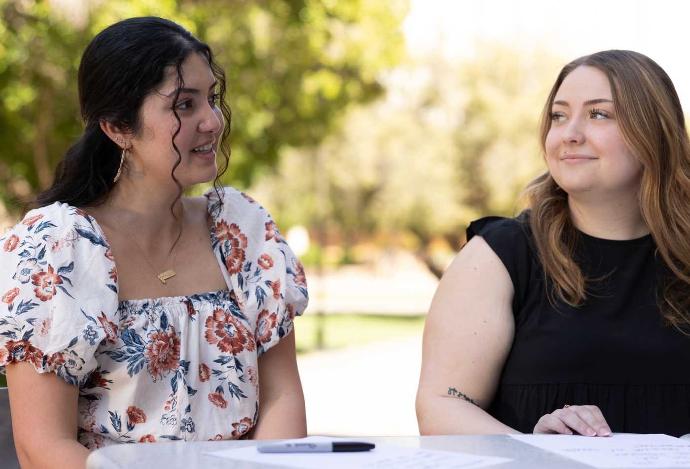 Students discuss coursework around a table, reflecting behavioral inquiry in ASU's Psychological Science (Graduate Certificate).