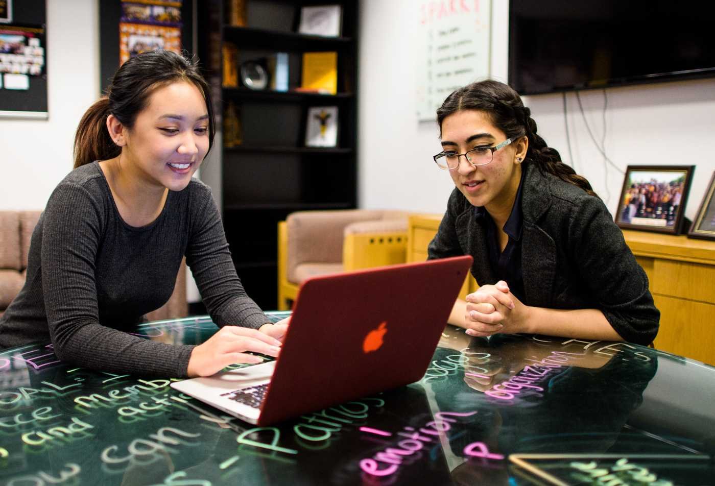 Two students analyze information on a laptop, supporting clear decision-making explored in ASU's Risk Communication certificate.