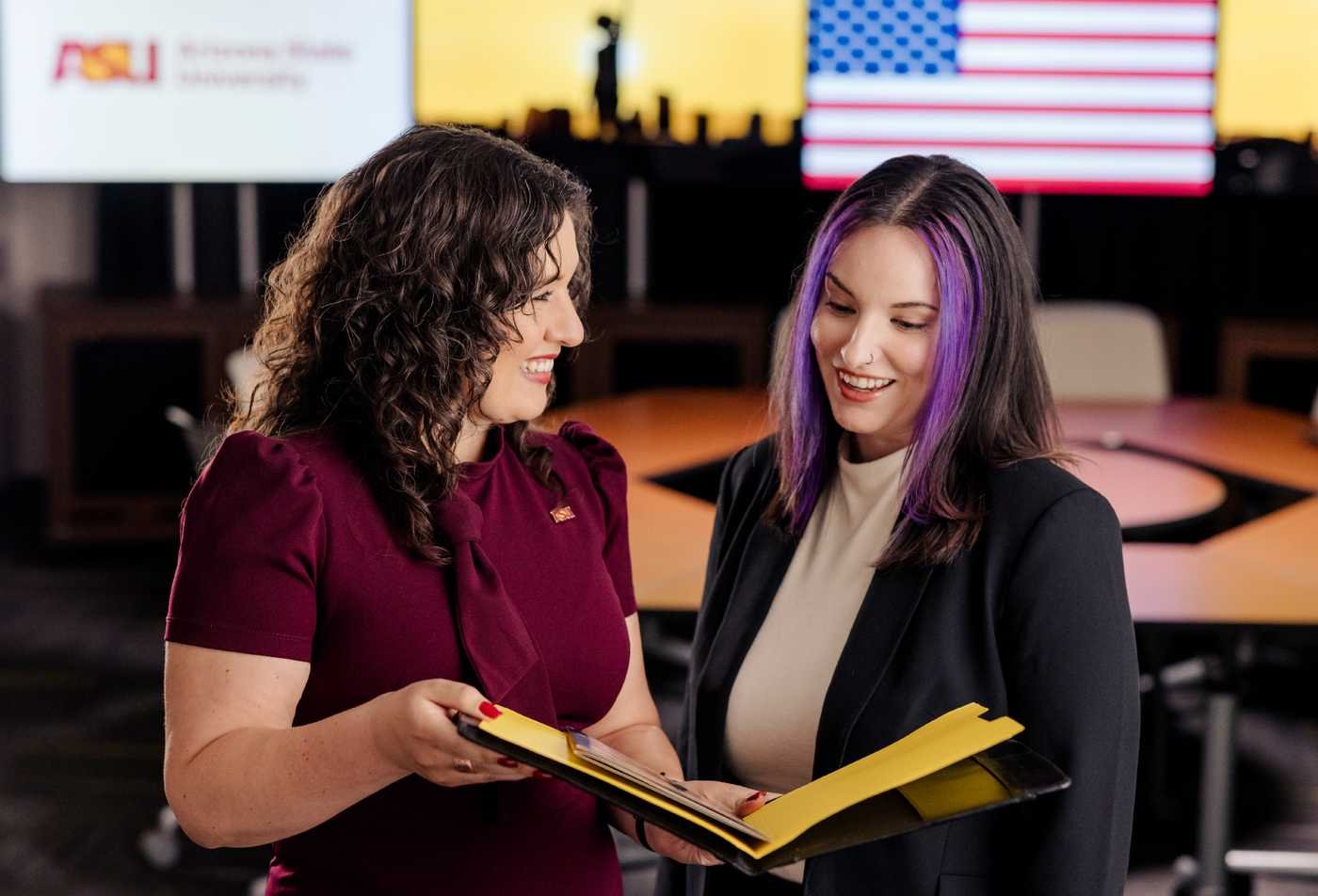 Professionals review ideas together in front of an American flag, reflecting civic perspectives in ASU's Social and Cultural Analysis (American Studies), BA program.